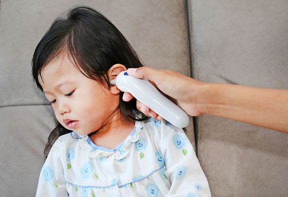 Mother takes temperature for her daughter with ear thermometer at home; Shutterstock ID 492778387; PO: 5725; Job: Lexus